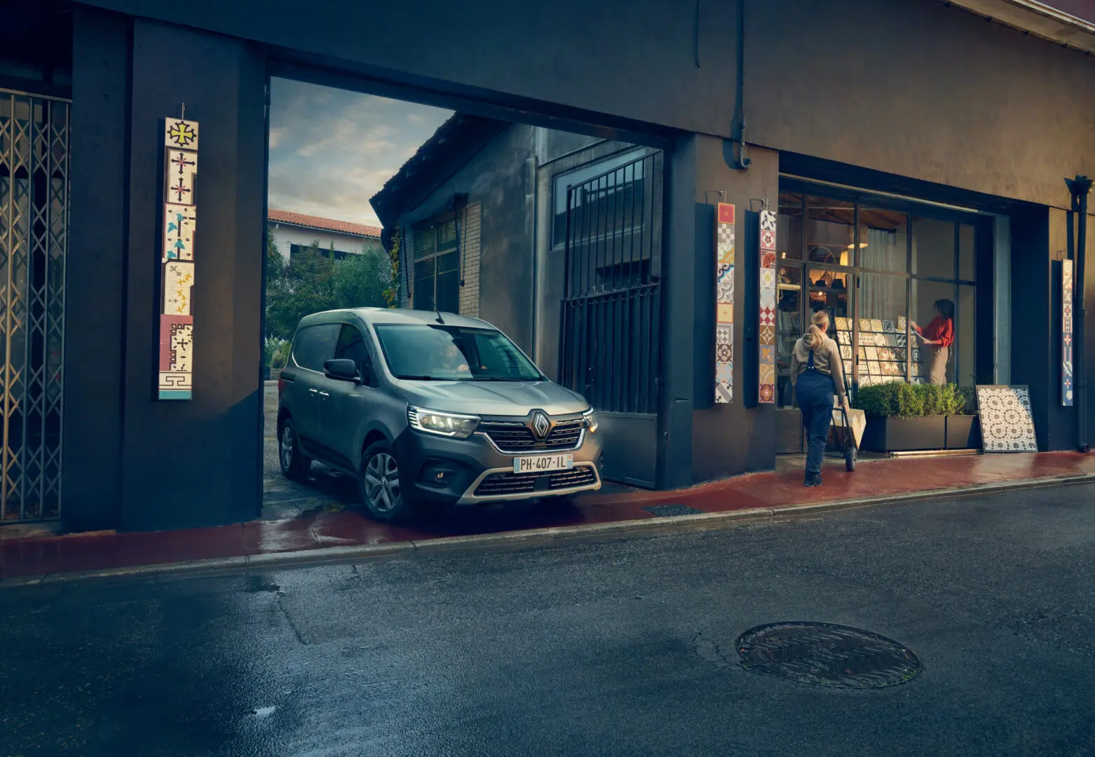 Renault Kangoo E-Tech electric de noche frente a una tienda