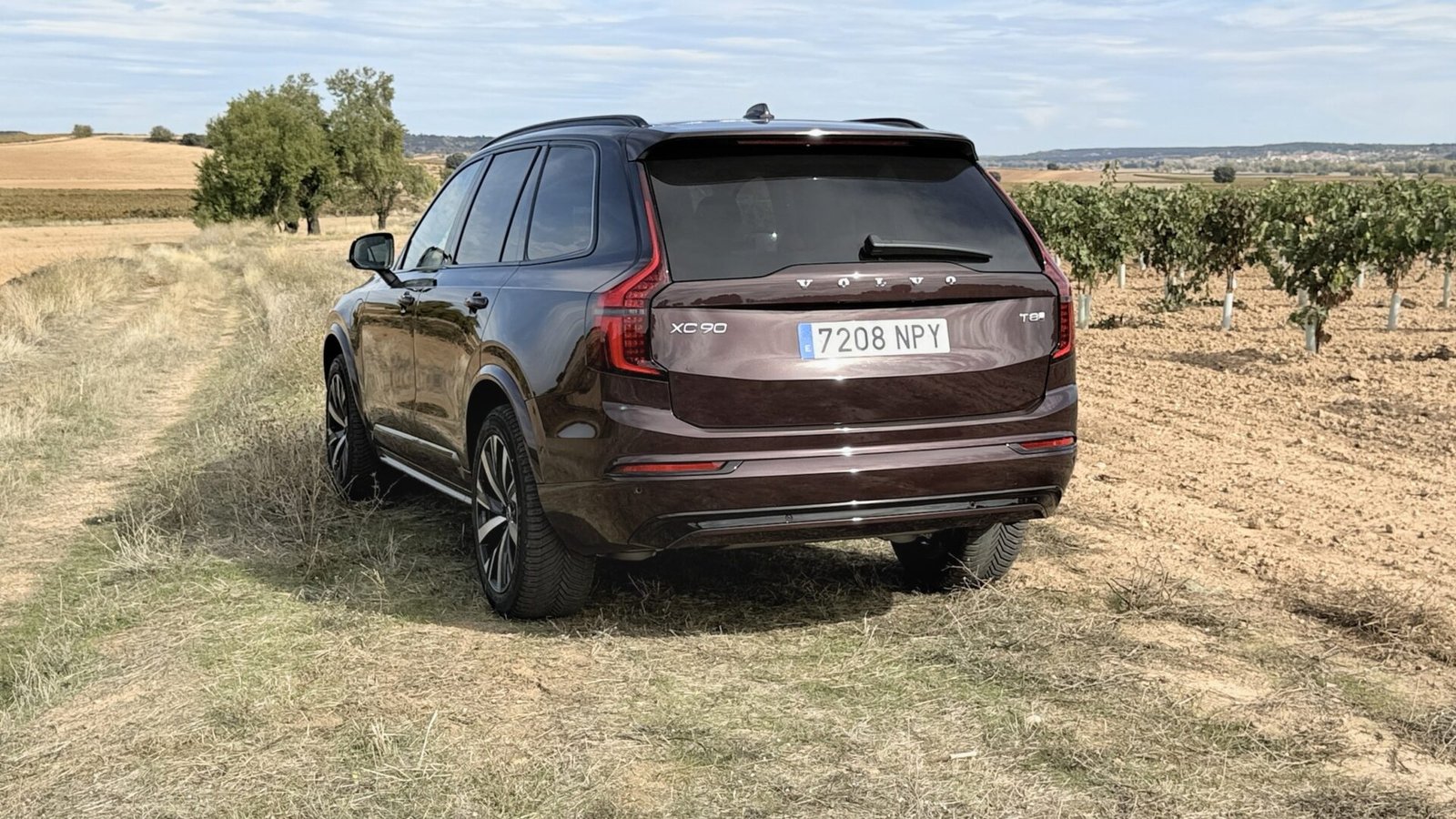 Vista trasera de tres cuartos del Volvo XC90 T8 en un camino rural