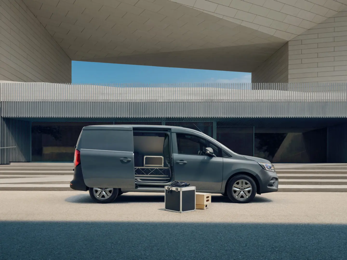 Renault Kangoo Van E-Tech electric gris aparcada junto a un edificio