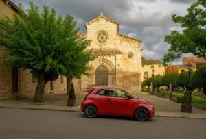 Fiat 500 Hybrid rojo aparcado frente a una iglesia
