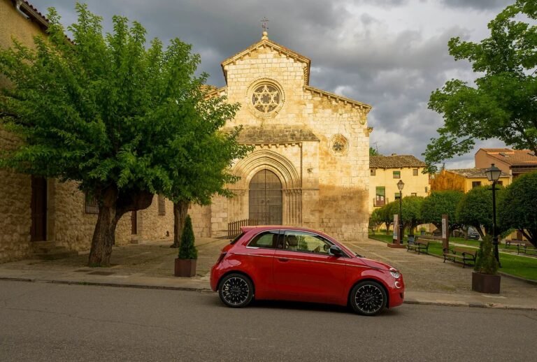 Fiat 500 Hybrid rojo aparcado frente a una iglesia