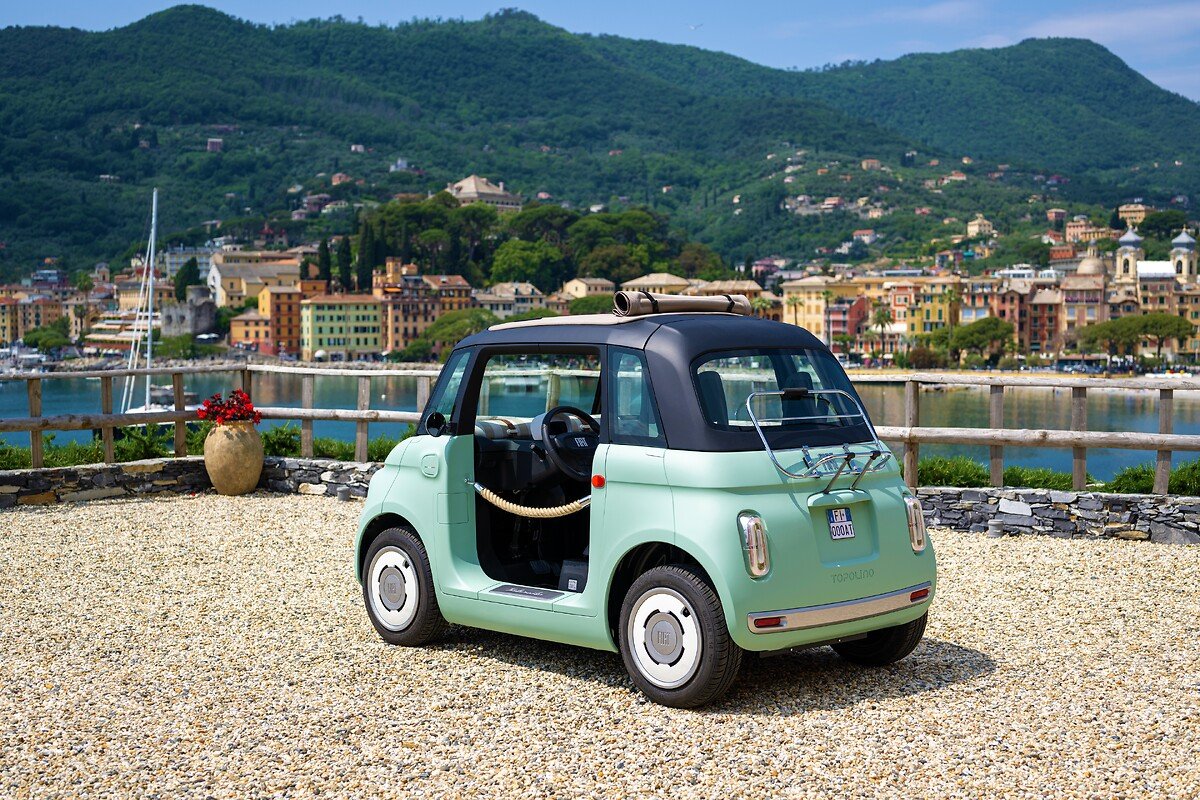 Fiat Topolino verde frente a un puerto mediterráneo
