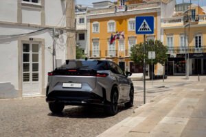 Lexus RZ 2027 F SPORT en color Sonic Platinum circulando por carretera