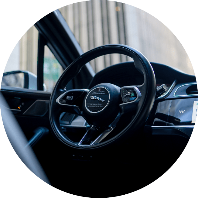 Interior del robotaxi Waymo sin conductor con el volante y la pantalla de navegación